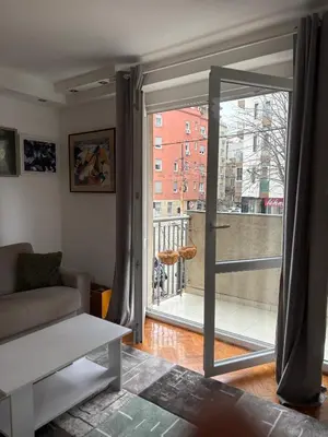 a living room with a sliding glass door to a balcony at Apartman Sasha 3 - Free parking in Belgrade