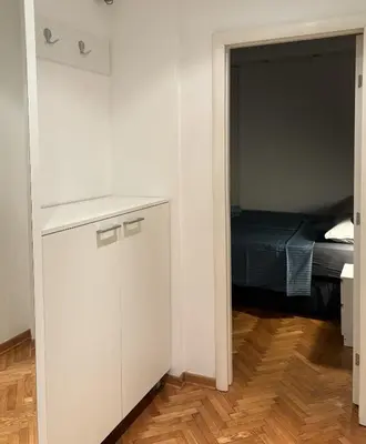 a room with a white cabinet and a bed at Apartman Sasha 3 - Free parking in Belgrade