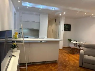a kitchen with a counter and a table and chairs at Apartman Sasha 3 - Free parking in Belgrade