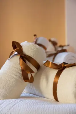a stack of towels with brown bows on a bed at Apartment Vukanja in Belgrade