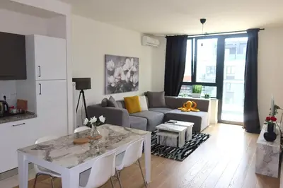 a living room with a table and a couch at Beograd na vodi Belgrade waterfront - Great city view in Belgrade
