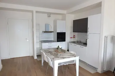 a white kitchen with a white table and chairs at Beograd na vodi Belgrade waterfront - Great city view in Belgrade