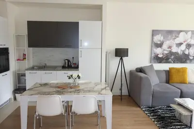 a kitchen and living room with a table and a couch at Beograd na vodi Belgrade waterfront - Great city view in Belgrade