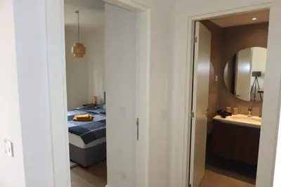 a bedroom with a bed and a sink and a mirror at Beograd na vodi Belgrade waterfront - Great city view in Belgrade