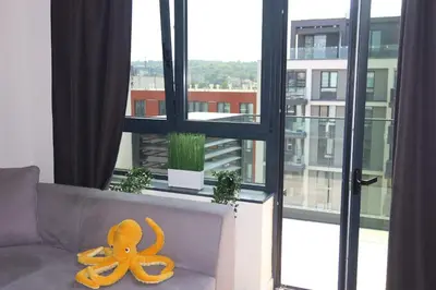 a stuffed octopus sitting on a couch in front of a window at Beograd na vodi Belgrade waterfront - Great city view in Belgrade