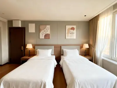 two beds in a room with two lamps at Sky Vista Hotel in Ledine