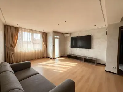 a living room with a couch and a flat screen tv at Sky Vista Hotel in Ledine