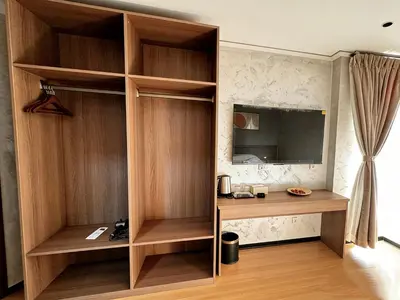 a room with a wooden book shelf and a tv at Sky Vista Hotel in Ledine