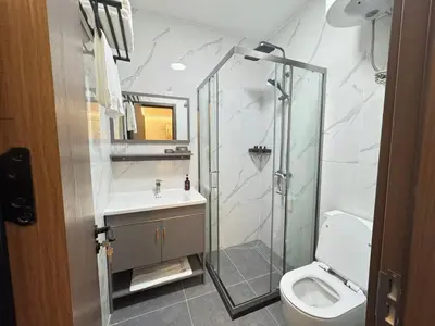 a bathroom with a shower and a toilet and a sink at Sky Vista Hotel in Ledine