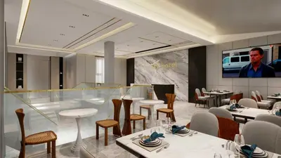 a restaurant with tables and chairs and a man on a screen at Sky Vista Hotel in Ledine