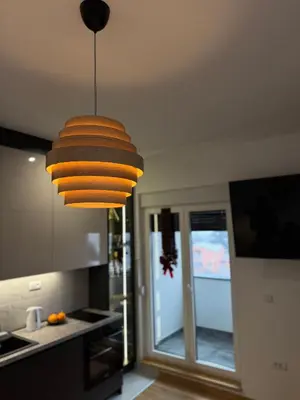a kitchen with a large light hanging from the ceiling at DUMA Apartmani Arandjelovac in Arandjelovac