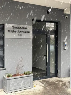 a building with a glass door with a sign on it at DUMA Apartmani Arandjelovac in Arandjelovac