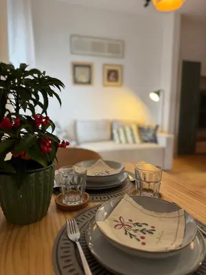 a dining room table with plates and utensils on it at DUMA Apartmani Arandjelovac in Arandjelovac