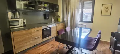 a kitchen with a black table and chairs and a microwave at Calm & Central Two Bedroom Apartment in Belgrade