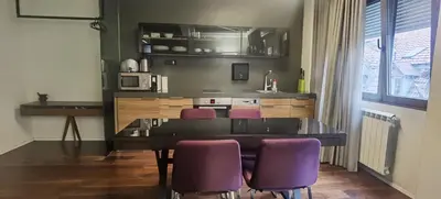 a kitchen with a dining table and purple chairs at Calm & Central Two Bedroom Apartment in Belgrade