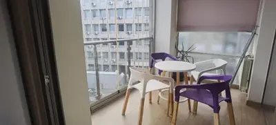 a room with a table and chairs and a window at Calm & Central Two Bedroom Apartment in Belgrade