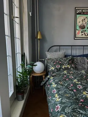 a bedroom with a bed and a plant and a lamp at Cozy Apart Central Oasis in Belgrade