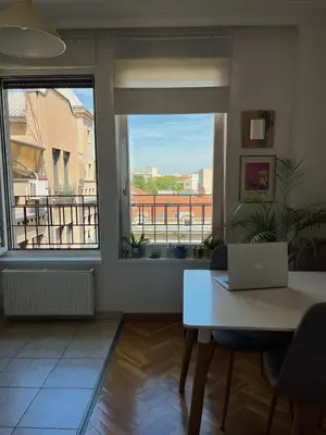 a room with a table and a window with a laptop at Cozy Apart Central Oasis in Belgrade