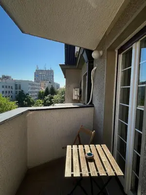 a wooden bench sitting on a balcony with a window at Cozy Apart Central Oasis in Belgrade