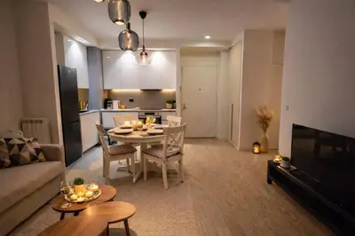 a living room with a dining room table and a kitchen at Metropoliten Apartments Belgrade Waterfront in Belgrade