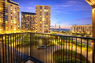 a balcony with a view of a city at night at Metropoliten Apartments Belgrade Waterfront in Belgrade