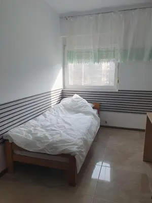 an unmade bed in a room with a window at Cute 3-bedroom apartment at nice place in Pančevo in Pančevo