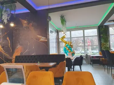 a restaurant with tables and chairs and a wall with a mural at Cute 3-bedroom apartment at nice place in Pančevo in Pančevo