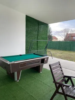 a pool table and a chair on a lawn at Stan na dan Pecinci in Pećinci