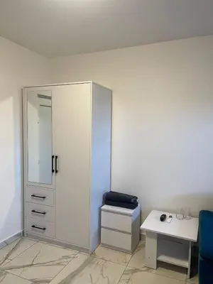 a white room with a cabinet and a table at Stan na dan Pecinci in Pećinci