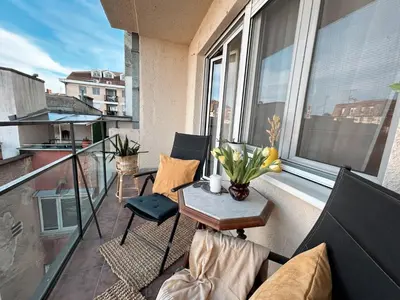 a balcony with a couch and a table with flowers on it at Ollio - Art of Dorcol in Belgrade