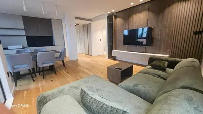a living room with a couch and a television on a wall at Zemun Golax Apartments in Belgrade