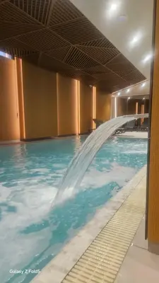 a pool with a water fountain in a building at Zemun Golax Apartments in Belgrade