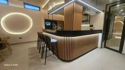 a bar in a restaurant with chairs and a counter at Zemun Golax Apartments in Belgrade