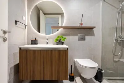 a bathroom with a sink and a toilet and a mirror at Belgrade Waterfront - Beograd na Vodi - Sensa in Belgrade