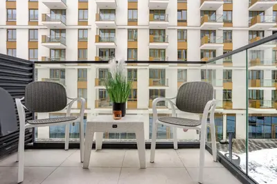 a table and chairs on a balcony with a building at Belgrade Waterfront - Beograd na Vodi - Sensa in Belgrade