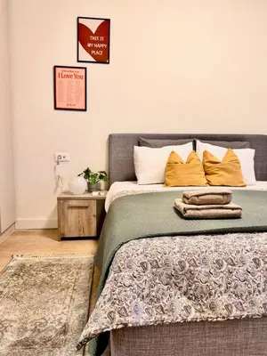 a bedroom with a bed with orange pillows at BW Luna - stay inspired! in Belgrade