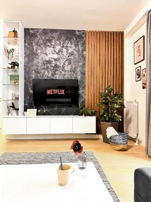 a living room with a television on a wall at BW Luna - stay inspired! in Belgrade