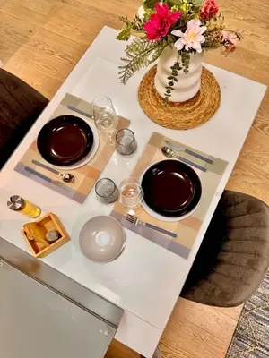 a table with two plates and a vase with flowers at BW Luna - stay inspired! in Belgrade