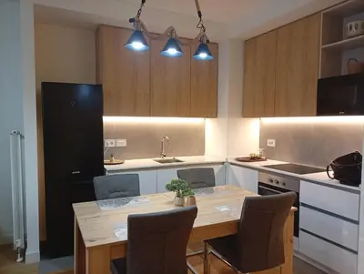 a kitchen with a wooden table and a black refrigerator at 2 Beograd na Vodi Belgrade Waterfront posaljite poruku radi info o nacinu ulaska i preuzimanje kljuca in Belgrade