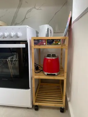 a red tea kettle on a cart next to a stove at Apartman Titi in Smederevo