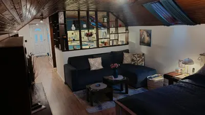 a living room with a blue couch and a bed at Apartman Pavle Mladenovac in Mladenovac