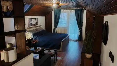 a bedroom with a bed with blue sheets and a window at Apartman Pavle Mladenovac in Mladenovac