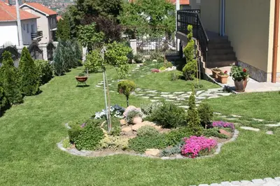 a garden with flowers and plants in a yard at Apartman Pavle Mladenovac in Mladenovac