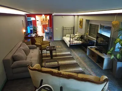 a living room with a couch and a tv at Paws & Pines Hideaway in Belgrade