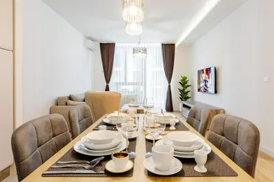 a dining room with a wooden table and chairs at Belgrade Waterfront - Beograd na vodi - Beograd in Belgrade