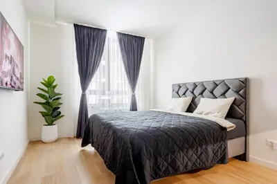 a bedroom with a bed and a large window at Belgrade Waterfront - Beograd na vodi - Beograd in Belgrade
