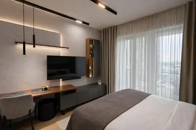 a bedroom with a bed and a desk with a television at Modern Premium Studio - Belgrade Waterfront - Verde in Belgrade