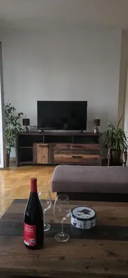 a bottle of wine and two wine glasses on a table at City Stay Apartments in Belgrade