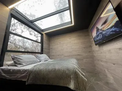a bedroom with a bed with a large window at Progar Waterfront Cabin House in Progar