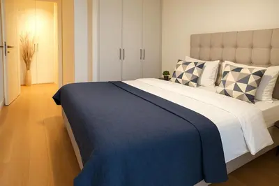 a bedroom with a large bed with a blue blanket at Echo Residence - Belgrade Waterfront in Belgrade